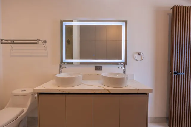 Detalle del tocador de doble lavabo con pared de listones de madera