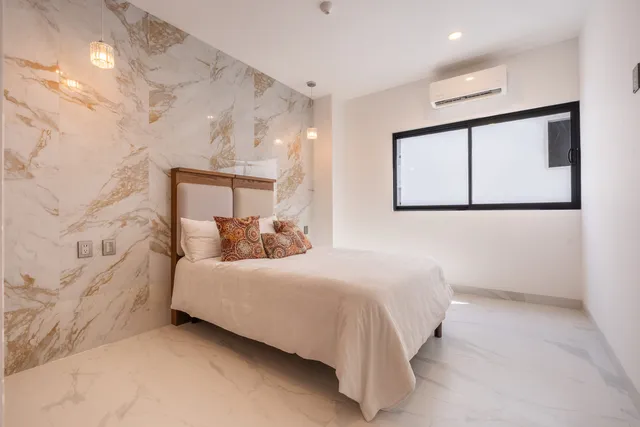 Segunda recámara con pared de mármol y ventana